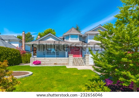 Custom built luxury house with nicely trimmed front yard, lawn in a residential neighborhood. Vancouver Canada.