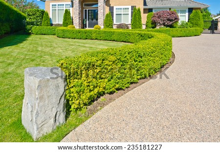 Nicely  trimmed and landscaped front yard and doorway of the big luxury house in the suburbs of Vancouver. Landscape design.