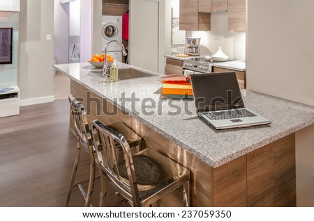 Kitchen counter with laptop and the vase with some fruits on it. Interior design.
