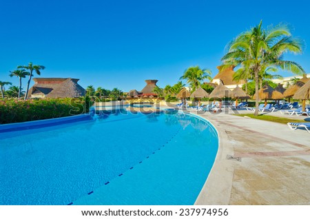 Swimming pool with deep blue sky and dark blue water at the luxury caribbean mexican resort.