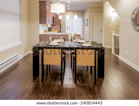 Luxury living suite : dining room with decorated table and the kitchen at the back. Interior design.