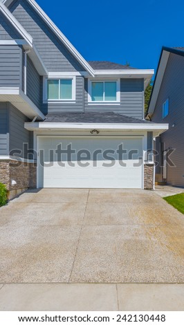 Double doors garage with wide long driveway. North America. Vertical.