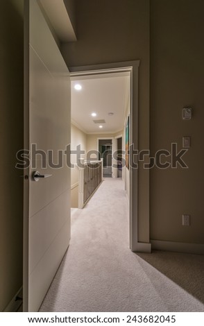 Corridor on the upper level of a house with the stairs and the room at the end. Interior design. Vertical.