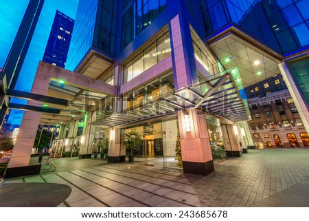Entrance, fragment  to the building lobby. Night scene of colorful city life with skyscrapers, highrise buildings. Vancouver downtown  at night.