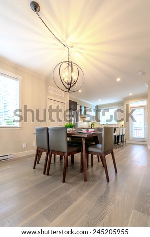 Nicely decorated dining table and the kitchen at the back. Interior design. Vertical.