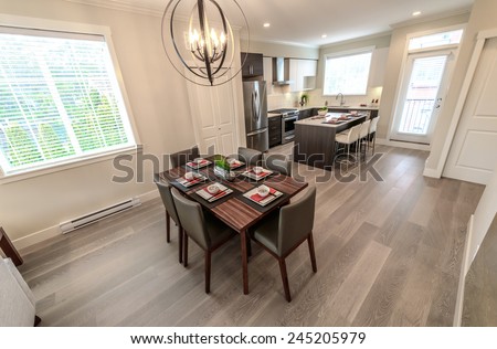Nicely decorated dining table and the kitchen at the back. Interior design. View from above.