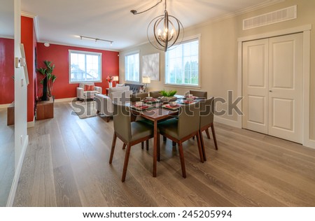 Nicely decorated dining table and living room at the back. Interior design.
