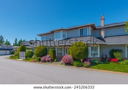 Custom built luxury house with nicely trimmed and landscaped front yard lawn in a residential neighborhood. Vancouver Canada.