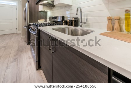 Cutting desk with wooden spoon and fork  and salt and pepper mills and oil and vinegar containers as a decorative element of the luxury modern kitchen. Interior design.