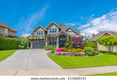 Big luxury custom made house with nicely landscaped front yard and driveway to garage in the suburb of Vancouver, Canada.