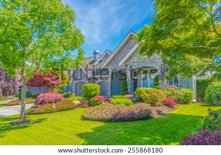 Big luxury custom made house with nicely landscaped front yard and driveway to garage in the suburb of Vancouver, Canada.