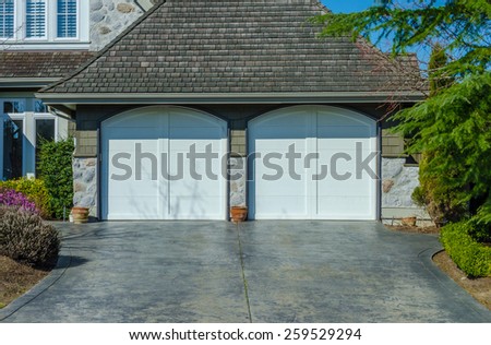 Double doors garage with wide, long driveway. North America. Vertical.