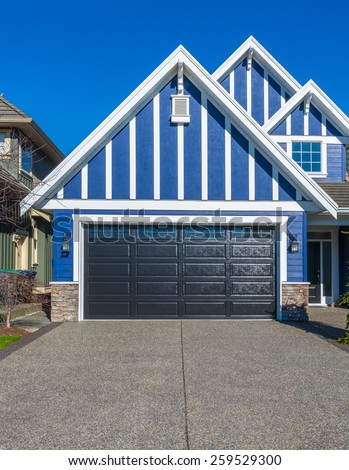 Double doors garage with wide, long driveway. North America.