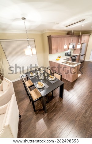 View from above: luxury living suite, nicely decorated dining table and the kitchen at the back. Interior design. Vertical.