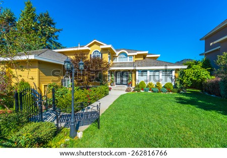 Big custom made luxury house with nicely trimmed and landscaped front yard  in the suburb of Vancouver, Canada.