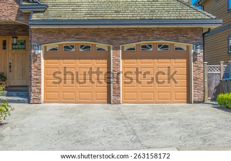 Double doors garage with wide, long driveway. North America. Canada.