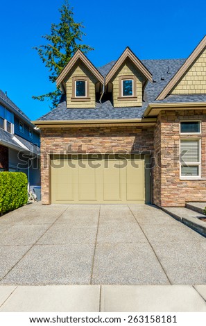 Double doors garage with wide, long driveway. North America. Canada. Vertical.