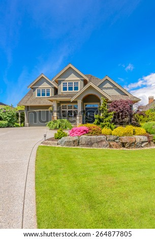 Big custom made luxury house with nicely landscaped front yard and driveway to garage in the suburb of Vancouver, Canada. Vertical.