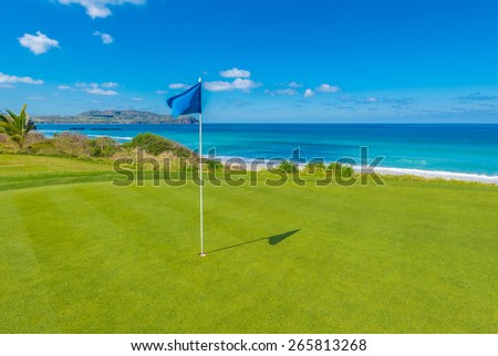Gorgeous view at the golf course with blue flag at the ocean side. Gorgeous view at the golf course with blue flag at the ocean side.