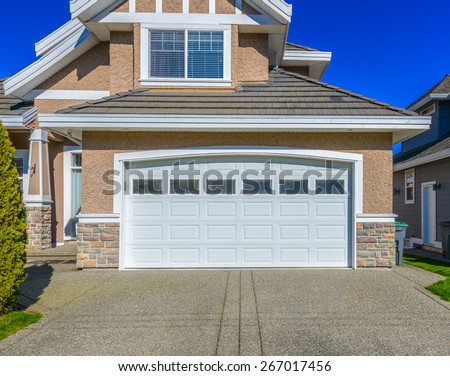 Double doors garage with wide, long driveway. North America. Canada.