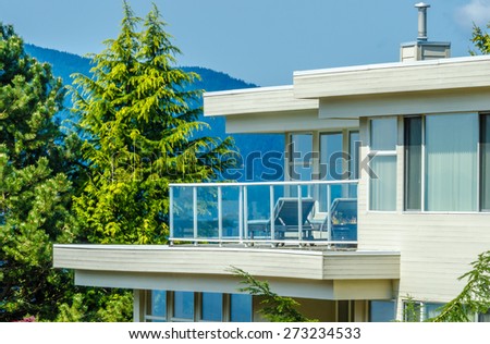 Architectural fragment: side of the modern  house with the balcony and windows.
