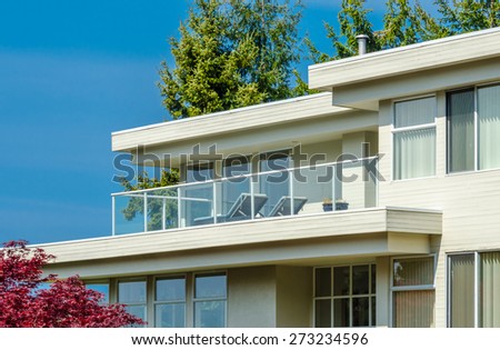 Architectural fragment: side of the modern  house with the balcony and windows.