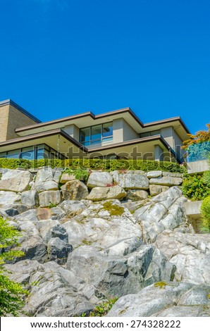Big custom made luxury modern house on the rocks with nicely landscaped front yard in the suburbs of Vancouver, Canada. Vertical.
