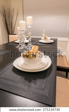 Napkins and candle holders on the nicely decorated and served dining table. Interior design of a brand new house.