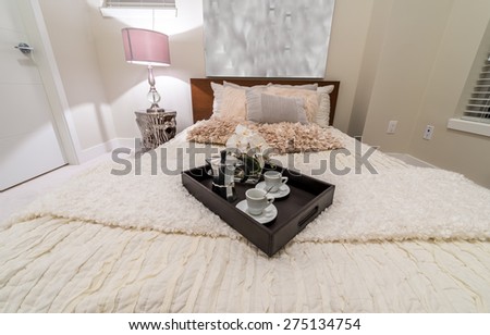 Decorative tray with the coffee set on the bed in the luxury modern  bedroom. Interior design.