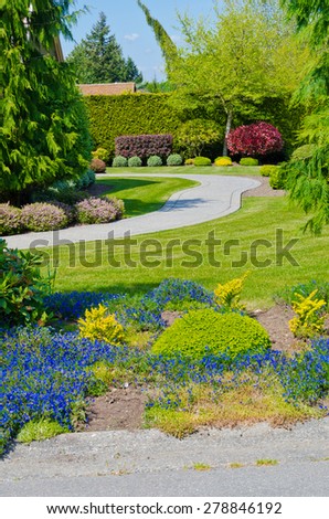 Trimmed bushes, flowers and stones in nicely decorated neighborhood. Landscape design.