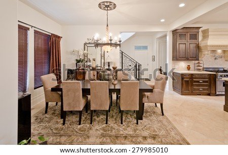Nicely decorated dining, lunch room with the kitchen at the back. Dining table and a few chairs around. Interior design.
