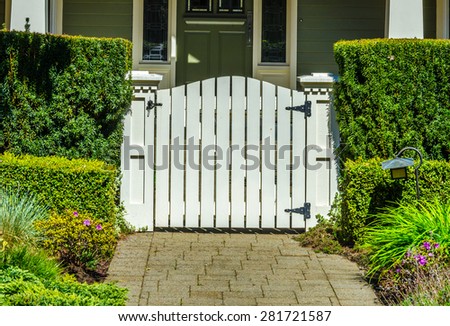 Country style gate, wicket to the house entrance with nicely trimmed and landscaped front yard.