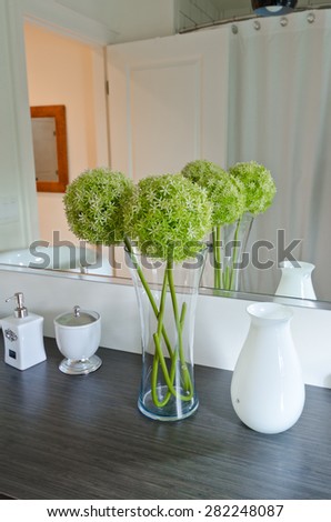 Fragment of the Interior design of a luxury bathroom with some flowers decoration on the counter