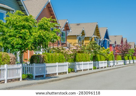 Nice and comfortable neighborhood, community. Some, line of homes behind the fence on empty street in the suburbs of the North America. Canada.