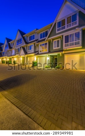 Townhouses, homes, community at  dusk, night time in suburbs of Vancouver, Canada. Vertical.