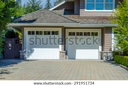 Double doors garage with nicely paved driveway. North America. Canada.