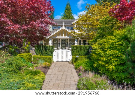 House entrance with nicely paved doorway and trimmed and landscaped front yard.