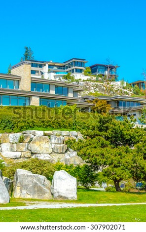 Great neighborhood with custom made luxury modern houses on the rocks with nicely landscaped front yards  in the suburbs of Vancouver, Canada. Vertical.