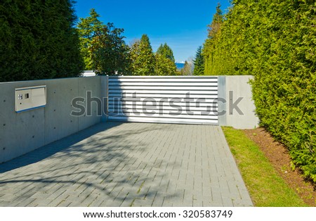 Modern gates with nicely paved driveway. driveway. North America.