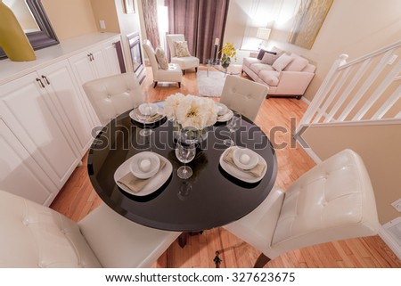 Luxury living suite with nicely decorated dining table, stylish mirror at the wall and the living room at the back . Interior design.