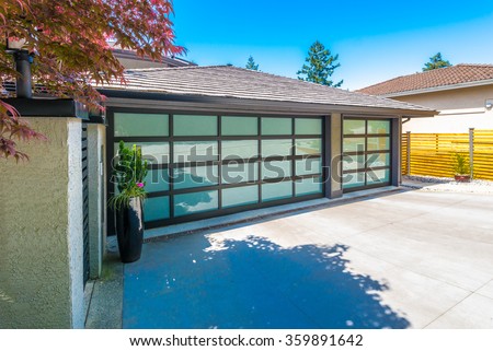 Garage with wide, long nicely paved driveway.