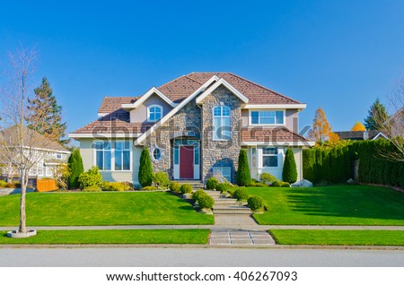 Big custom made luxury house with nicely trimmed and landscaped front yard in the suburb of Vancouver, in colorful fall time. Canada.