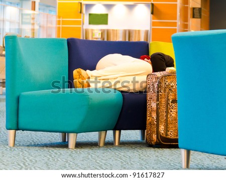 Sleeping woman (passenger) in the airport terminal  in anticipation of departure (landing) of an aircraft (or any transport). Flight delay due to weather or strike.