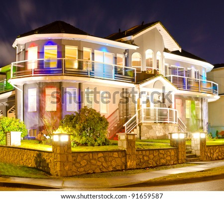 Luxury home exterior in the night time illuminated with lights