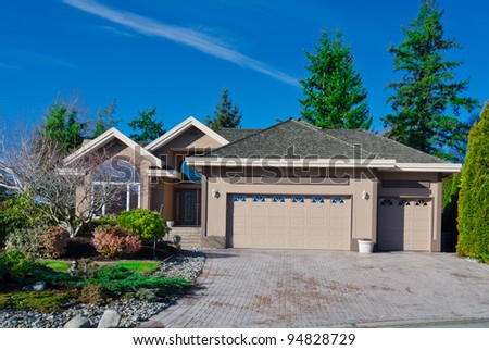 Home with covered entry and double three car garage with the dark blue sky in  Vancouver.