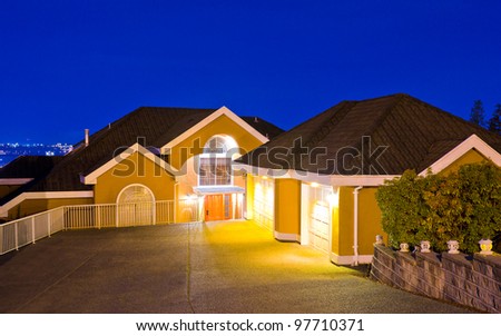 A big luxury house with double detached garage on the hills in suburbs at dusk ( night ) in Vancouver, Canada