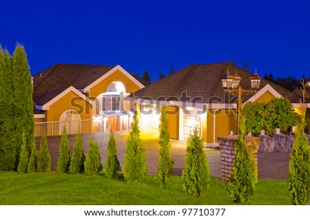 A big luxury house with double detached garage in suburbs at dusk ( night ) in Vancouver, Canada