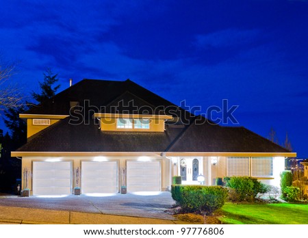 A big luxury house with triple garage in suburbs at dusk ( night ) in Vancouver, Canada