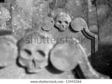 Keep Death at Bay: Black & White Grainy Image of Two Skulls on Gravestones in Headington Churchyard, Oxford England UK 2004