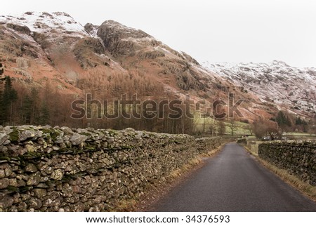 Empty Country Lane Beneath Mountain Peaks of Langdale Pikes, Lake District, Cumbria, England